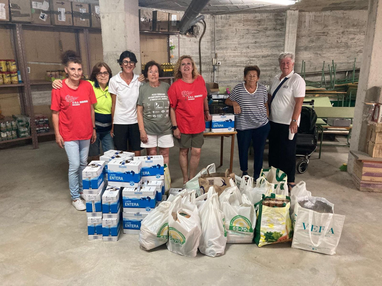 A group of people receive material donation at SOS Mamas