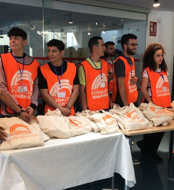 Youngsters in an office showing their different coloured new polo shirts