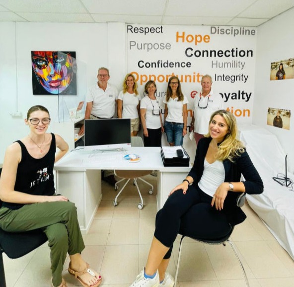 Two men inspecting donated printers at the YGB container