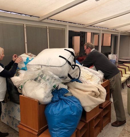 The YGB volunteers sort out piled up donations of bedding at Llar Inge