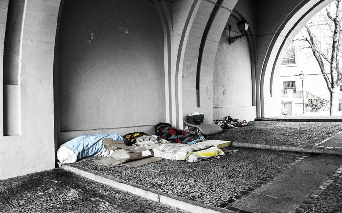 Homeless sleeping on mattresses in a passageway