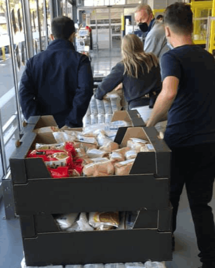 A large purchase of food items being pulled on a trolley