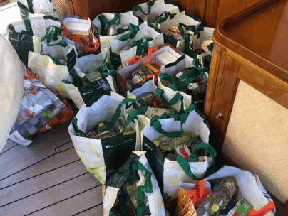 A large amount of ready made food bags for donation on the aft deck of a yacht