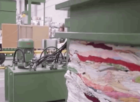 A machine pressing recycled textiles into a pallet at the sorting plant