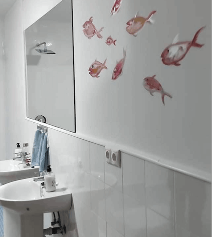 A bathroom with a mural with a fish motif on the wall